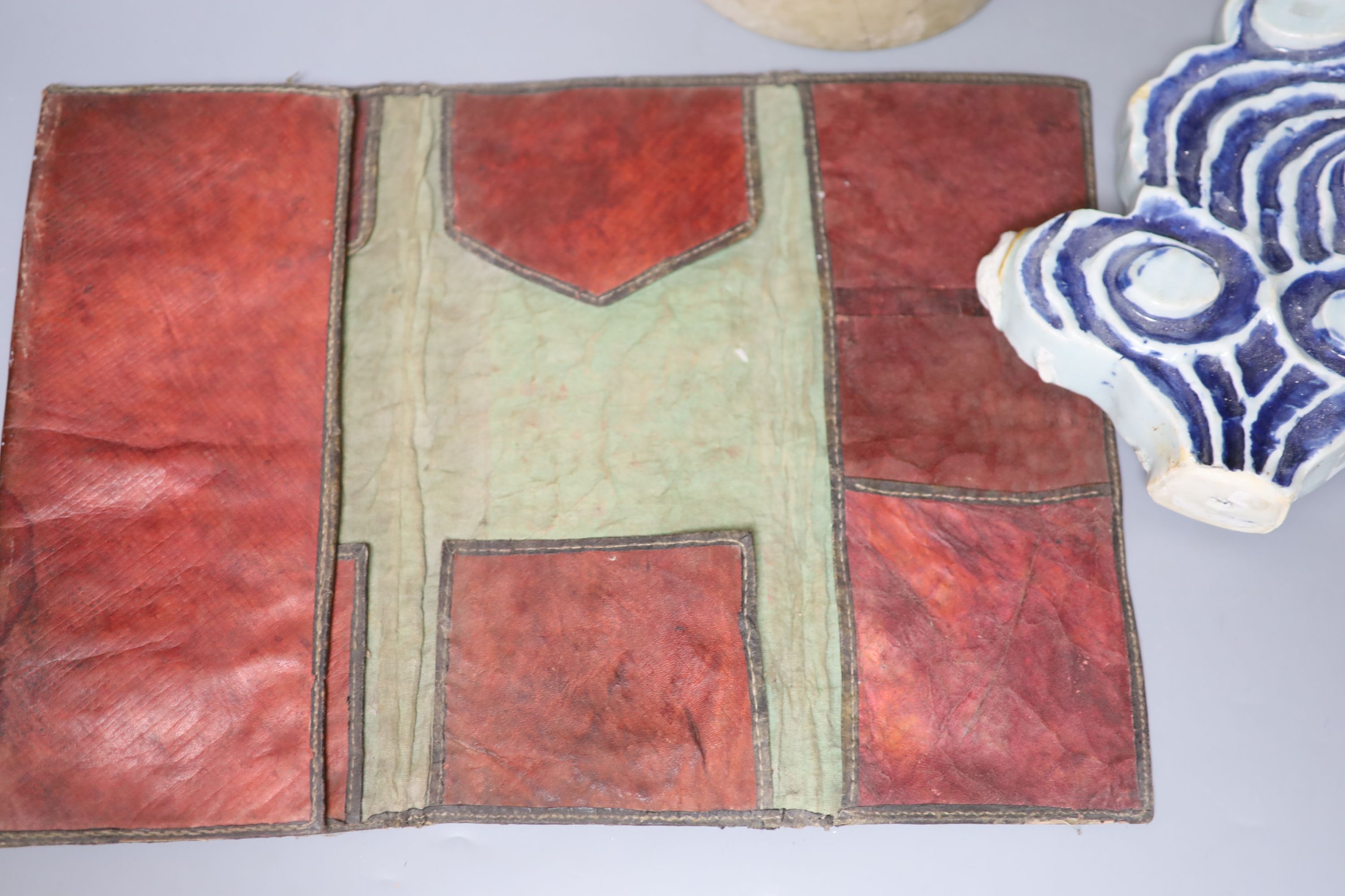 A Chinese blue and white Ming porcelain finial, a leather wallet. c.1920 and a cream stone cylinder, longest 29cm
